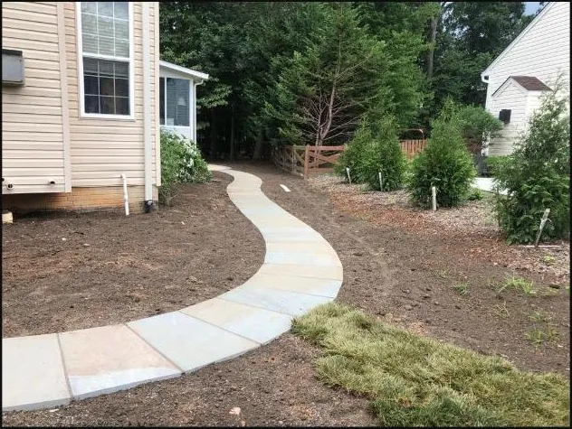 Curved stone walkway beside the home